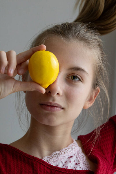 girl holding fresh lemons on light background healthy eating concept