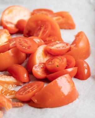 Taze domates dilimleri ve kağıt tepside kiraz domatesleri.