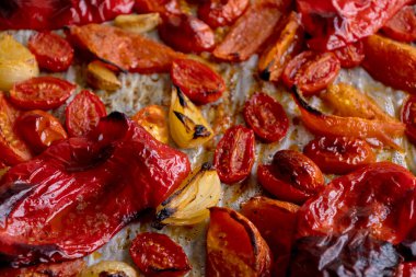 Kızarmış domates, kırmızı çan biberi, soğan, ve tepside sarımsak.