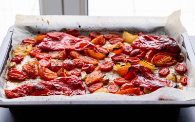 Kızarmış domates, kırmızı çan biberi, soğan, ve tepside sarımsak.