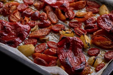 Kızarmış domates, kırmızı çan biberi, soğan, ve tepside sarımsak.