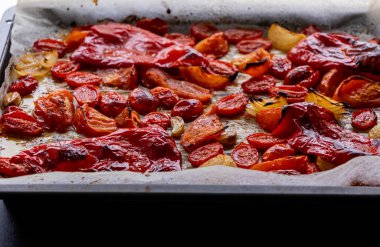 Kızarmış domates, kırmızı çan biberi, soğan, ve tepside sarımsak.