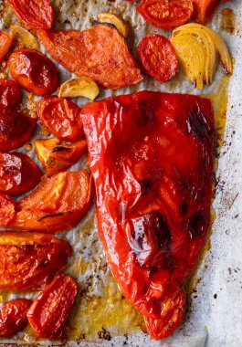 Kızarmış domates, kırmızı çan biberi, soğan, ve tepside sarımsak.