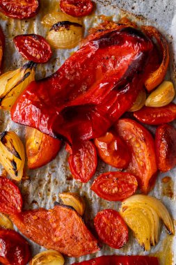 Kızarmış domates, kırmızı çan biberi, soğan, ve tepside sarımsak.