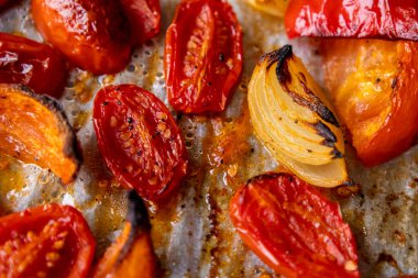 Kızarmış domates, kırmızı çan biberi, soğan, ve tepside sarımsak.