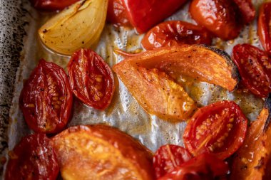 Kızarmış domates, kırmızı çan biberi, soğan, ve tepside sarımsak.