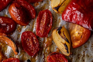 Kızarmış domates, kırmızı çan biberi, soğan, ve tepside sarımsak.