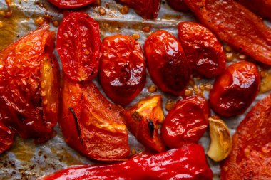 Kızarmış domates, kırmızı çan biberi, soğan, ve tepside sarımsak.