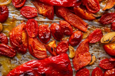 Kızarmış domates, kırmızı çan biberi, soğan, ve tepside sarımsak.