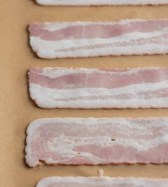 Pişirme tepsisindeki Parşömen Kağıdındaki Çiğ Pastırma Şeritleri Pişmeye Hazır