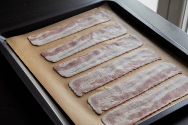 Pişirme tepsisindeki Parşömen Kağıdındaki Çiğ Pastırma Şeritleri Pişmeye Hazır