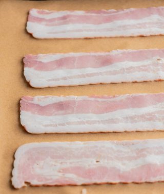 Pişirme tepsisindeki Parşömen Kağıdındaki Çiğ Pastırma Şeritleri Pişmeye Hazır