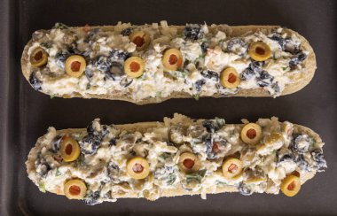 Peynir ve zeytin karışımlı ekmek aperatifi pişirmeye hazır.