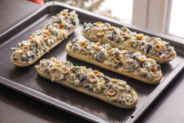 Peynir ve zeytin karışımlı ekmek aperatifi pişirmeye hazır.