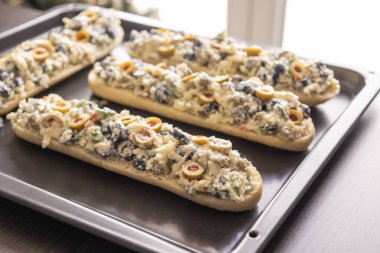 Peynir ve zeytin karışımlı ekmek aperatifi pişirmeye hazır.