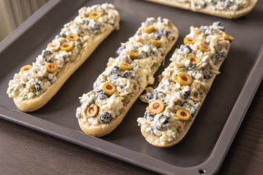 Peynir ve zeytin karışımlı ekmek aperatifi pişirmeye hazır.