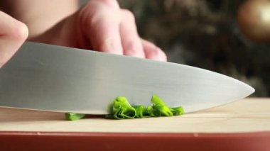 Taze yeşil soğan soğanları, yumuşak doğal ışıkla tahta bir kesme tahtasıyla doğranır.