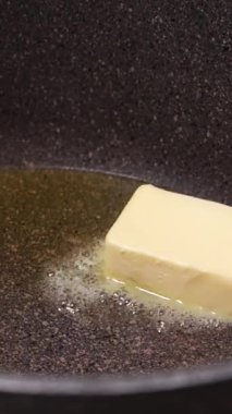 Bir tencerede eriyen tereyağı küpünün yakın çekimi