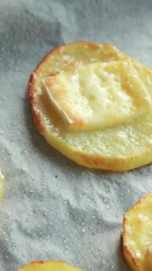 Erimiş peynirli fırında patates dilimleri.