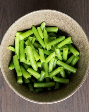 Koyu bir kâsede taze yeşil fasulye, sağlıklı yemek, bitki temelli yemekler ve sebze hazırlama kavramları için yakın çekim..