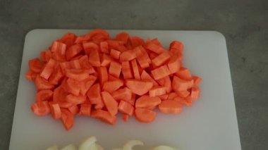 Dilimlenmiş soğan ve havuçların yakın çekim görüntüsü pişirmeye hazır. Sağlıklı yemek hazırlama, sebze hazırlama ve taze malzeme kavramları için ideal.