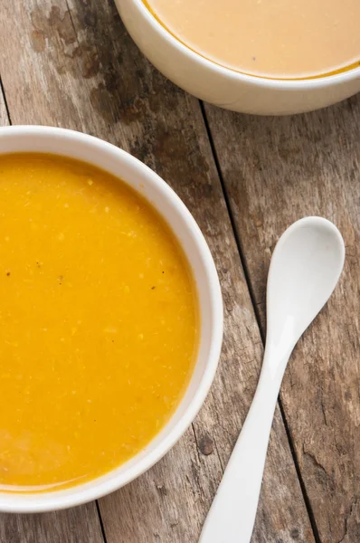 Two bowls of squash soup on wooden table — Stock Photo, Image