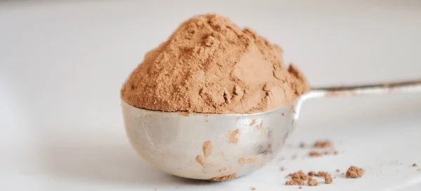 Cacao powder in silver spoon — Stock Photo, Image