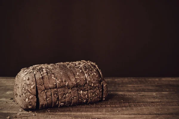 Pan de centeno en rodajas sobre una superficie de madera — Foto de Stock