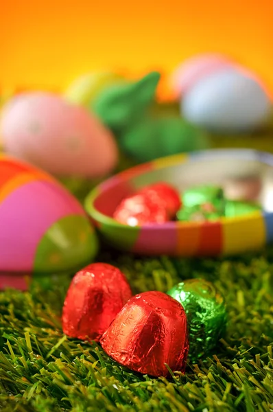 Chocolates and estar eggs on the grass — Stock Photo, Image