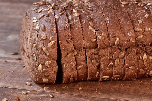 Krojonego chleba żytniego na powierzchni drewnianych — Zdjęcie stockowe