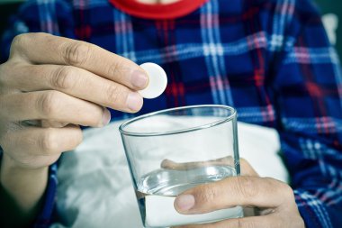 adam bir efervesan tablet bir bardak su ile içine koyarak