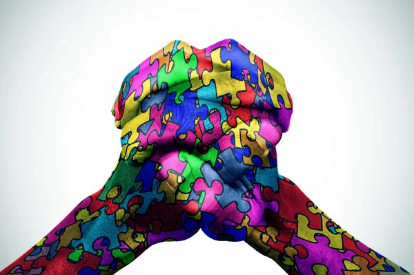 Man hands patterned with puzzle pieces of different colors — Stock Photo, Image