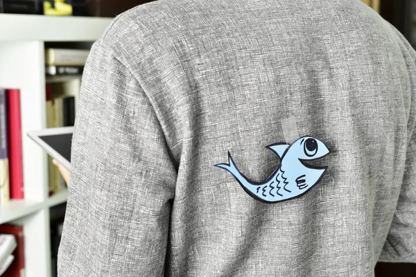 Young man with a paper fish attached to his back — Stock Photo, Image