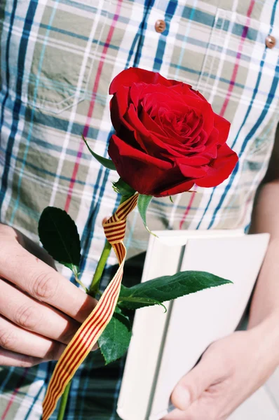 Mann mit einer Rose mit katalanischer Flagge und einem Buch — Stockfoto