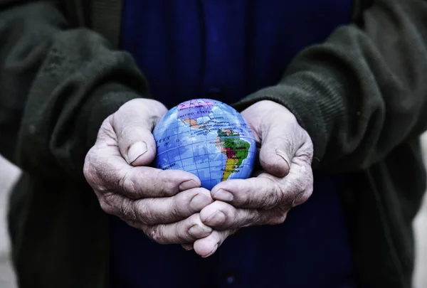 Velho homem com um globo mundial em suas mãos — Fotografia de Stock