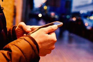 genç adam onun smartphone sokakta geceleri kullanarak.