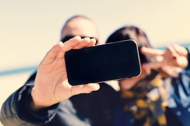 genç erkek ve kadın bir akıllı telefon ile bir selfie alarak