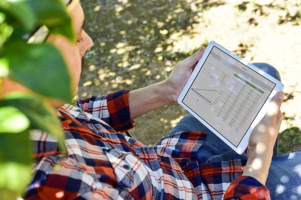 Farmář pozorovat některé grafy v počítači tablet — Stock fotografie