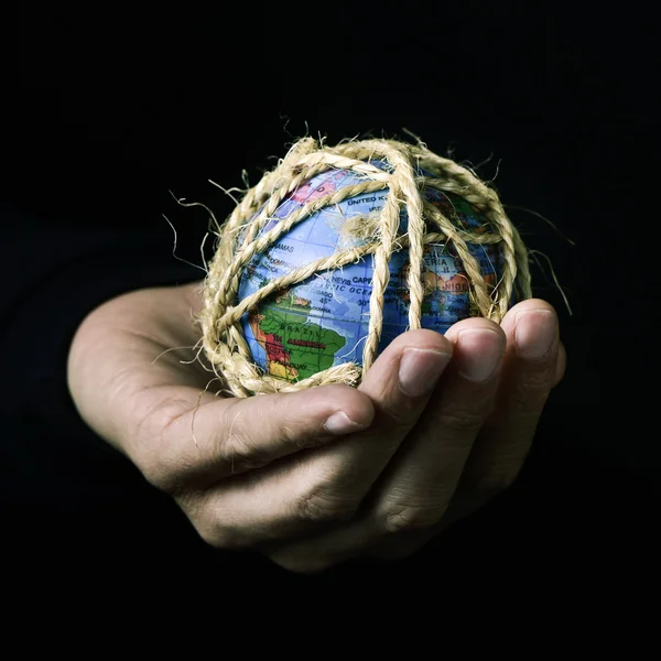 Man med en världen globe bunden med rep — Stockfoto