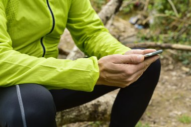 genç sporcu açık havada onun smartphone kullanarak