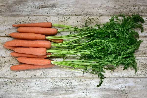 Zanahorias crudas sobre una mesa blanca rústica — Foto de Stock