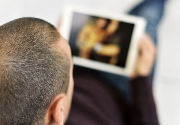 Junger Mann schaut Pornos in seinem Tablet — Stockfoto