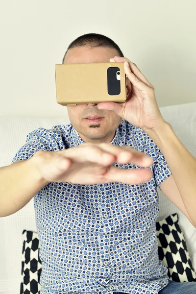 Jovem com lentes de realidade virtual de papelão — Fotografia de Stock