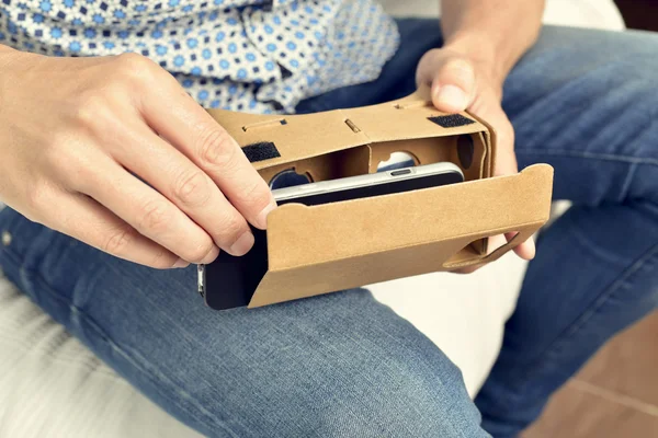Jovem com lentes de realidade virtual de papelão — Fotografia de Stock
