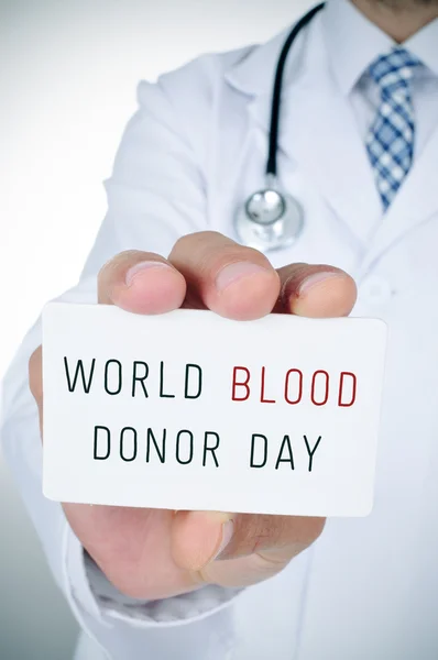 Médico com uma placa com o dia do doador de sangue texto — Fotografia de Stock