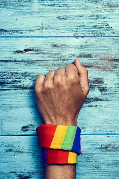 Człowiek z rainbow wzorzyste chustę w jego nadgarstku — Zdjęcie stockowe