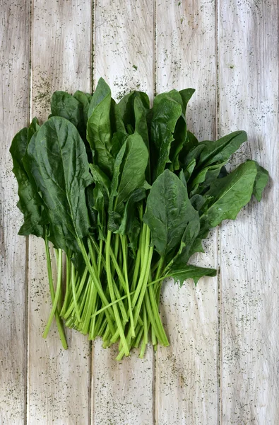 Raw spinach on a rustic white table — Stock Photo, Image