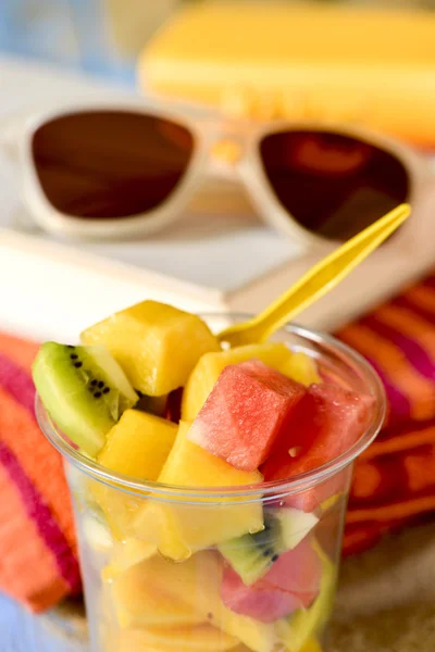 Frukt sallad, solglasögon, bok och stranden handduk — Stockfoto