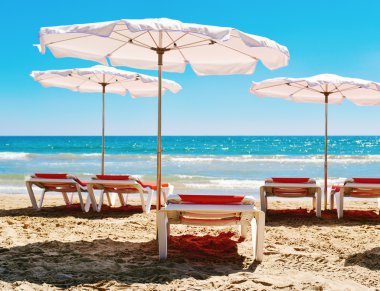 güneşlenme sandalyeli ve sessiz bir plaj şemsiye