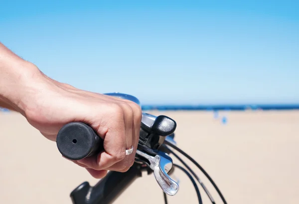 Jovem montando uma bicicleta junto ao oceano — Fotografia de Stock